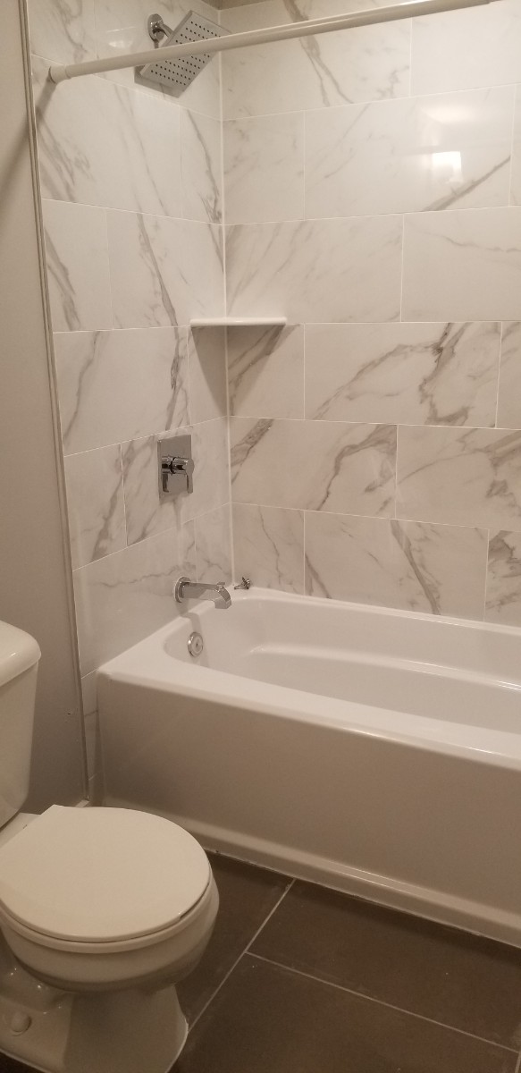White tiled bath tub and shower